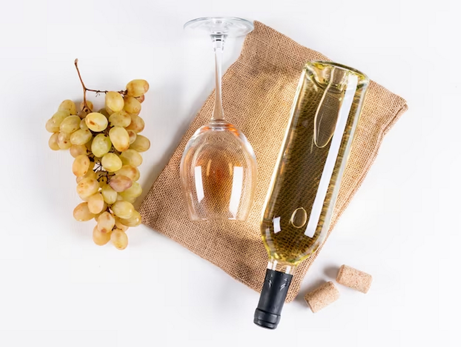 a bottle of wine, wine glass and grapes
