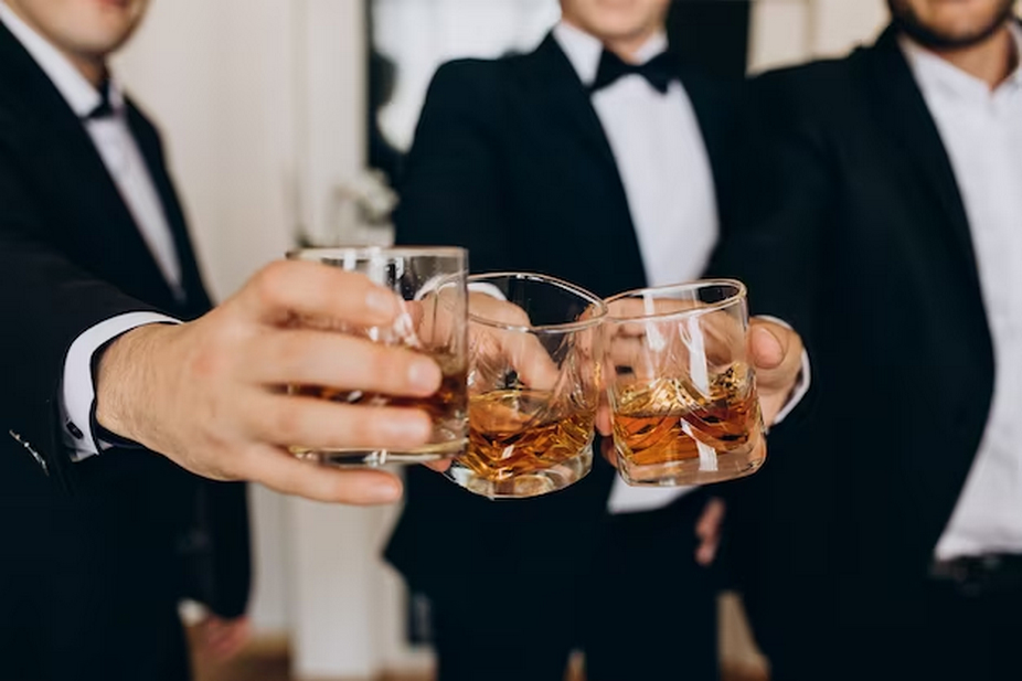 Men in coats, each holding a glass of whiskey.