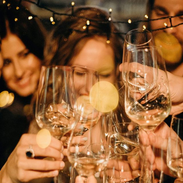 people are having fun and holding glasses of wine